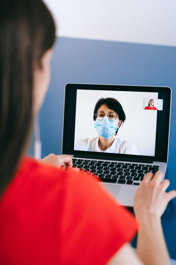A woman using a laptop to engage in a video call with her healthcare provider