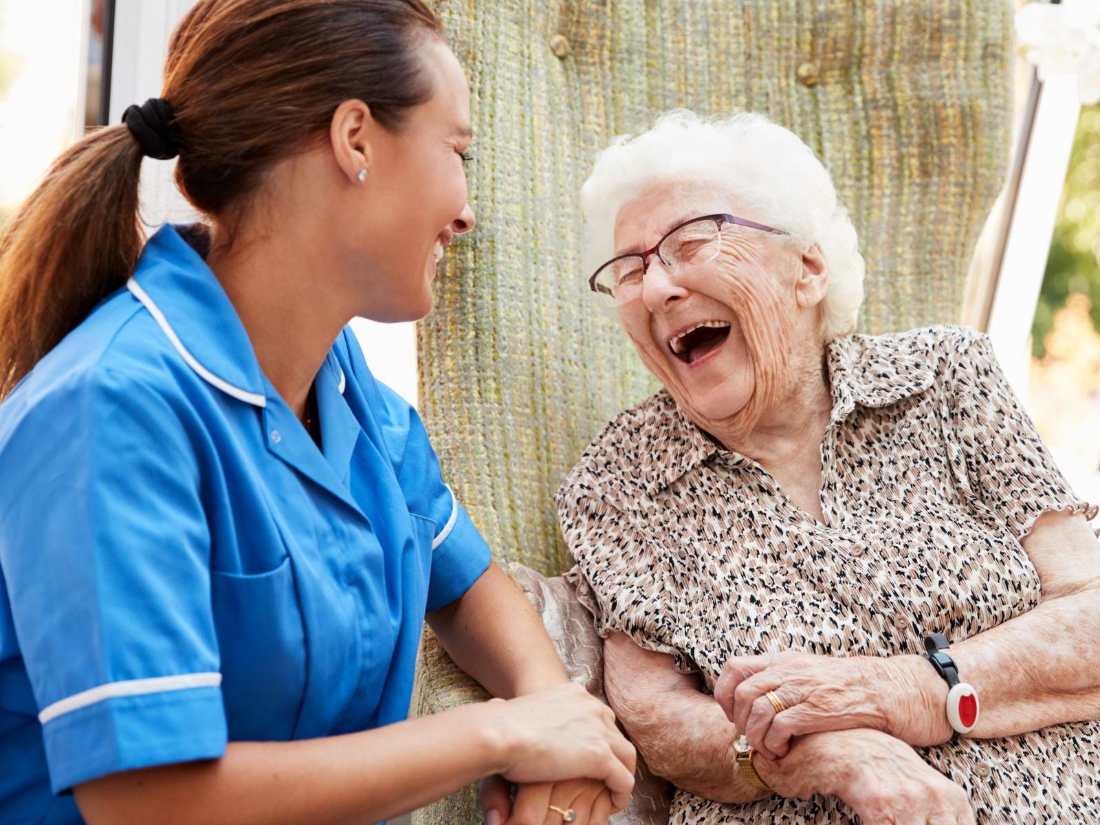 A nurse attending to a smiling patient as part of community care